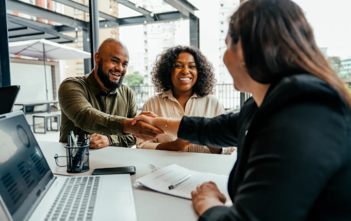A couple shaking hands with an agent