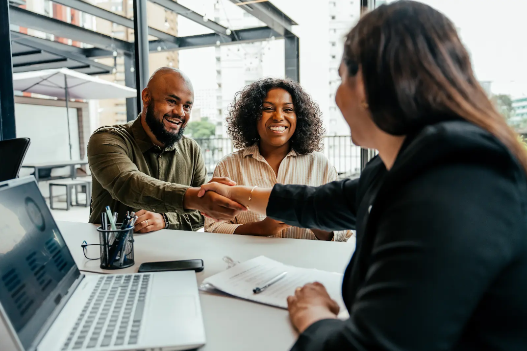 A couple shaking hands with an agent